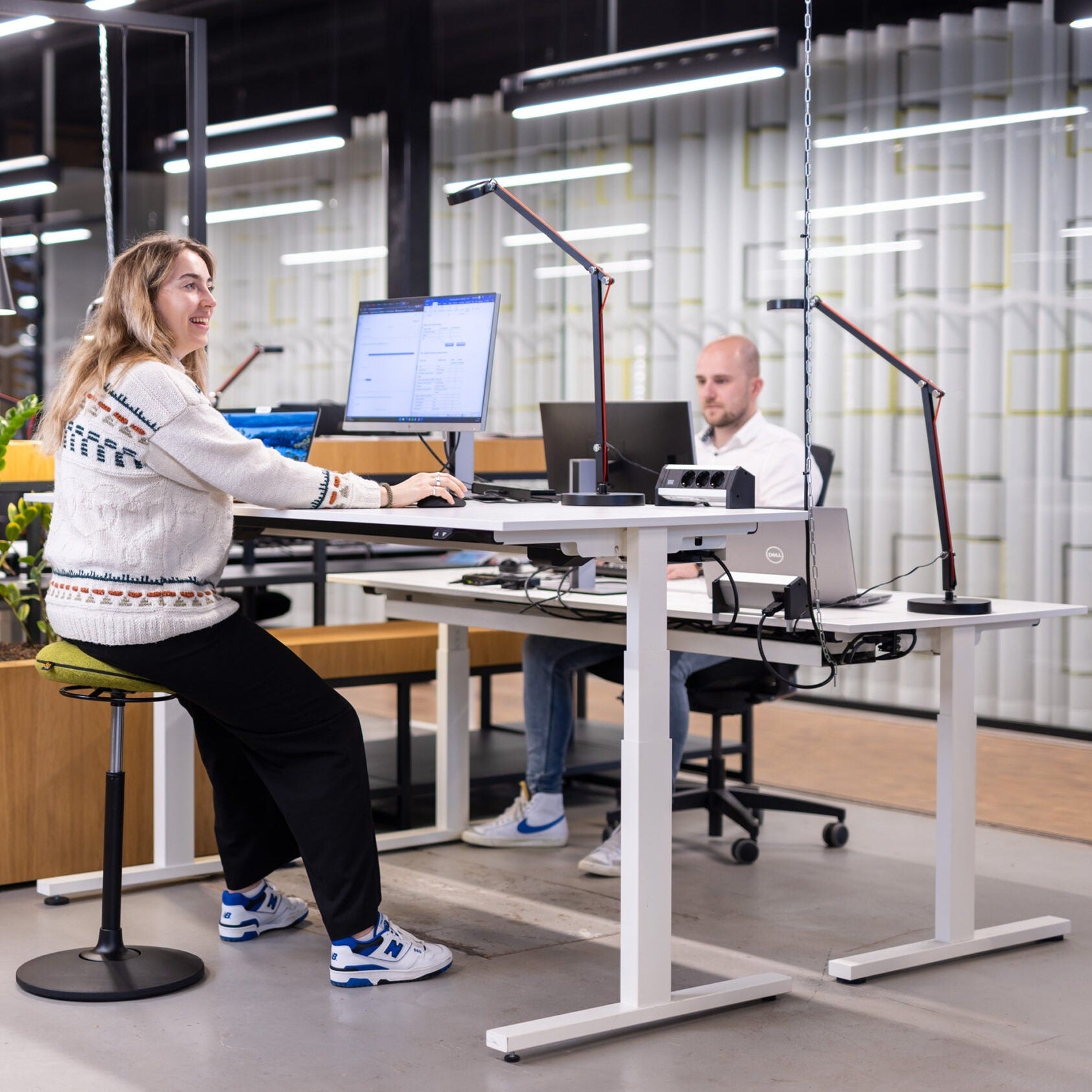 Twee mensen zitten op ergonomische VILT Steady krukken aan een counter, ideaal voor een actieve werkplek.