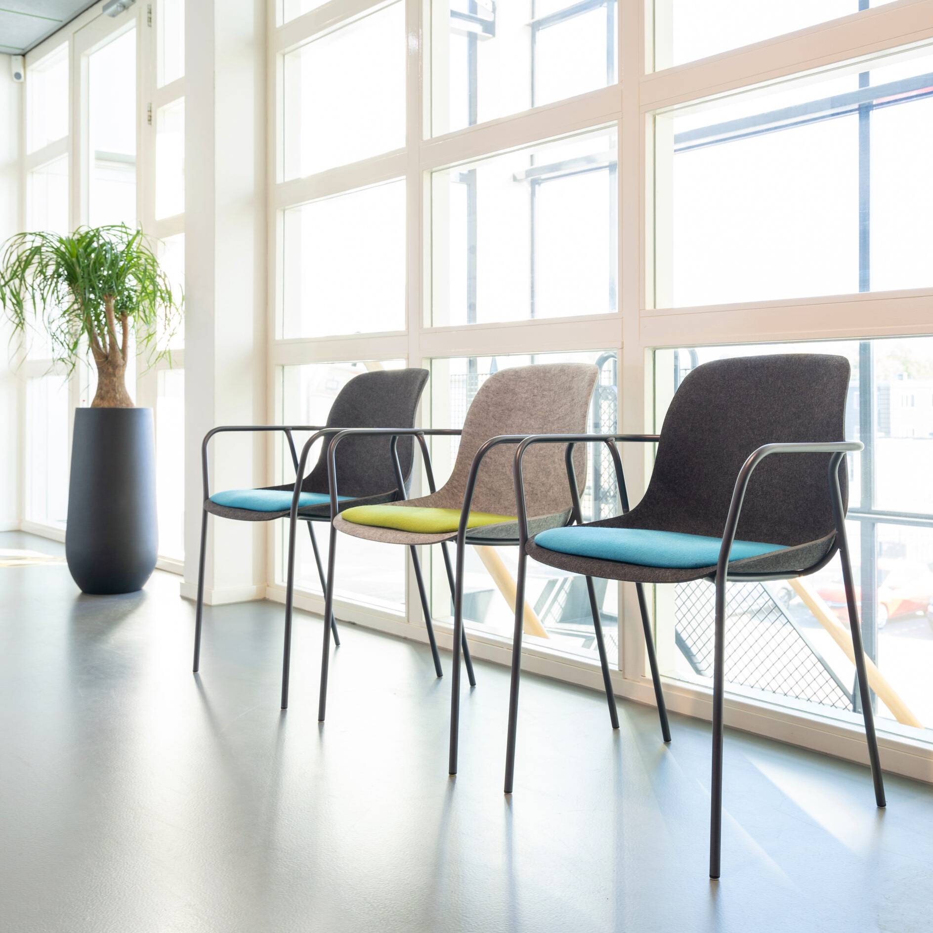Drie stijlvolle VILT Felt Fine stoelen voor grote ramen, perfect voor een moderne kantooromgeving.