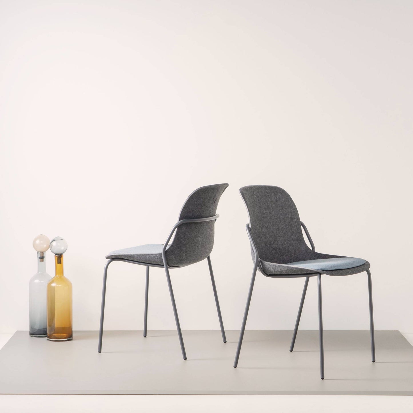 Twee elegante stoelen met zwarte benen en blauwe zittingen, ideaal voor een moderne en praktische kantoorinrichting.
