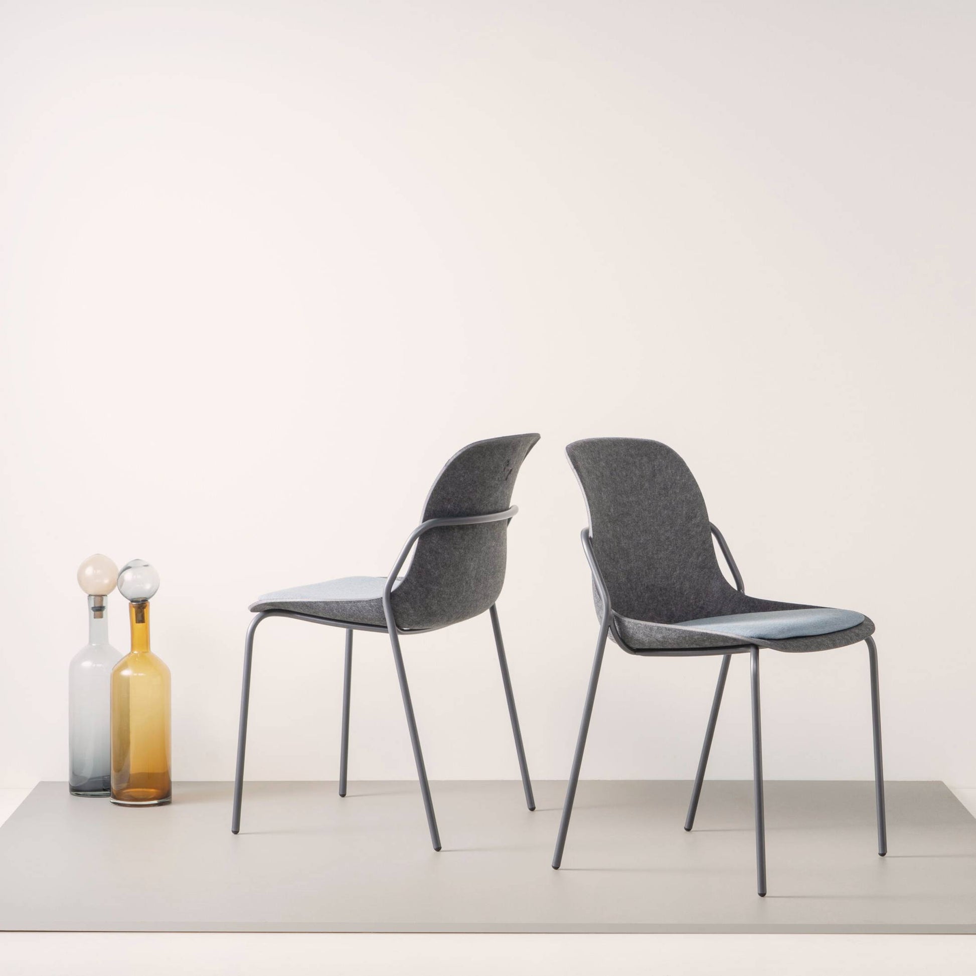 Twee elegante stoelen met zwarte benen en blauwe zittingen, ideaal voor een moderne en praktische kantoorinrichting.
