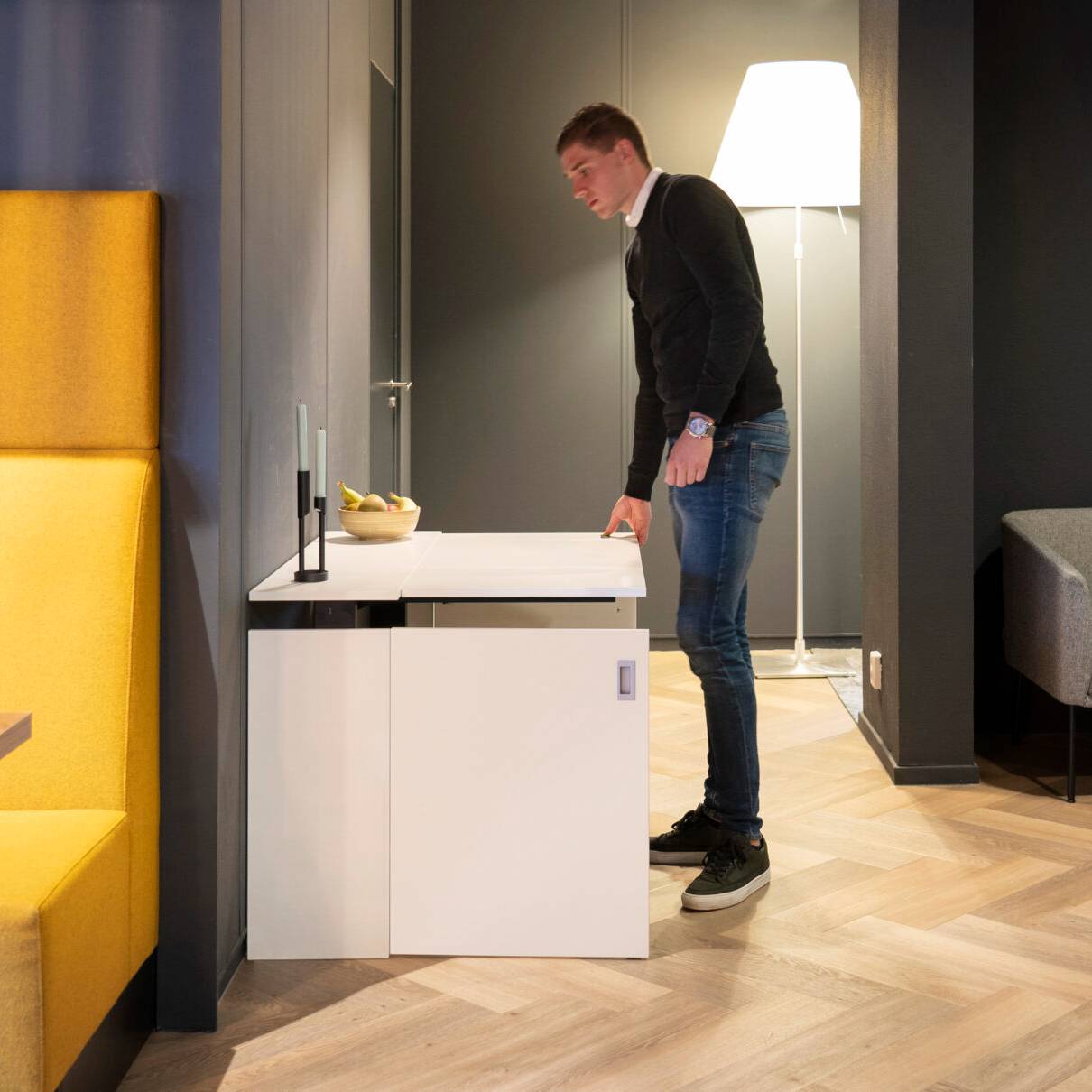 Man aan bureau met laptop, gebruikmakend van de HomeFit thuiswerkplek voor een comfortabele werkervaring.