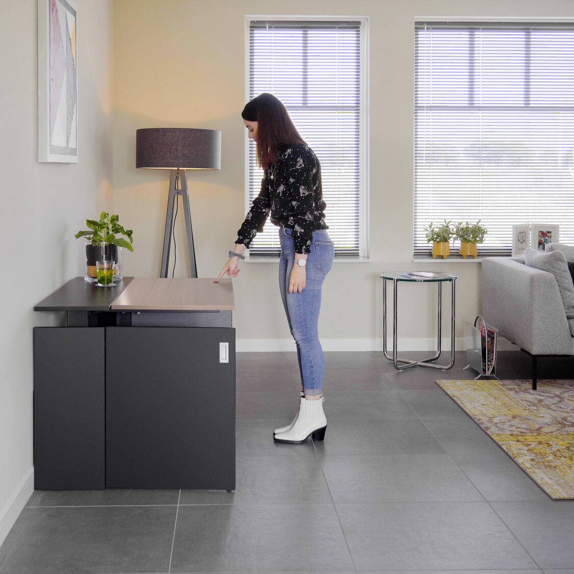 Vrouw voor een bureau met computer in de HomeFit thuiswerkplek, klaar om te werken.
